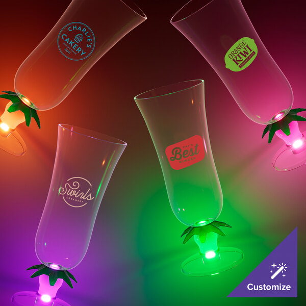 A close-up of a customizable plastic palm tree hurricane cup with an orange LED light.