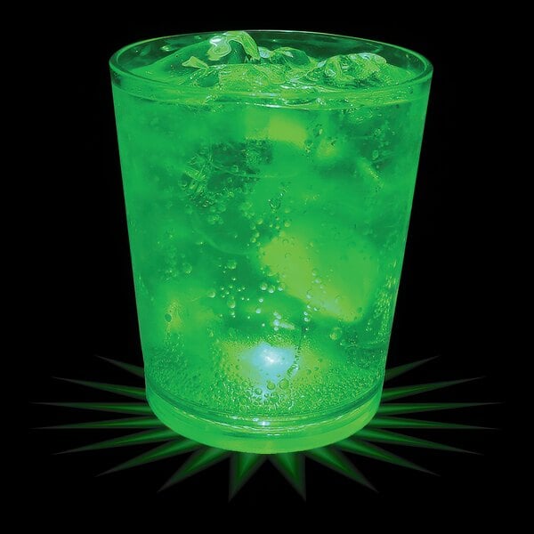 A 12 oz. customizable plastic rocks cup with a green LED light filled with a green drink and ice.