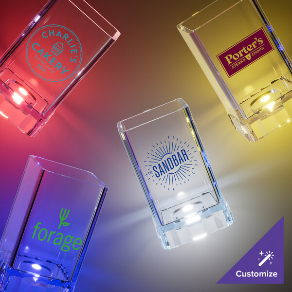 A group of customizable plastic square shot cups with yellow LED lights.