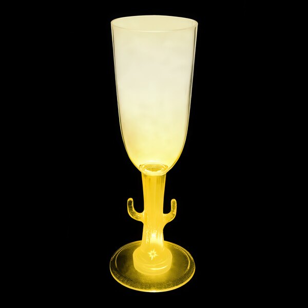 A yellow plastic champagne cup with a yellow LED light on a black background.