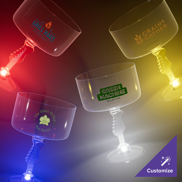 A group of clear plastic guitar stem margarita cups with blue LED lights.