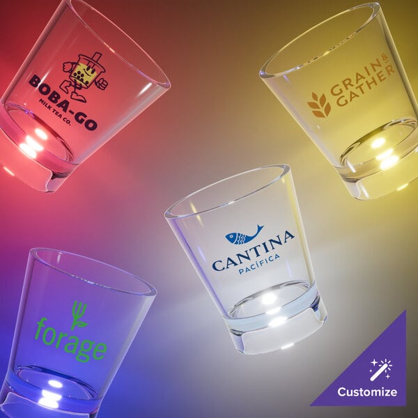 A close-up of a customizable plastic shot glass with a blue LED light. Several customizable plastic shot glasses with different logos.