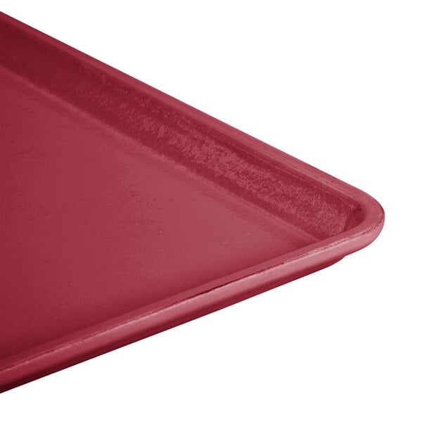 A close-up of a red Cambro dietary tray with a plastic handle.