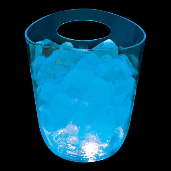 A customizable plastic champagne bucket with blue LED lights and ice inside on a table in a cocktail bar.