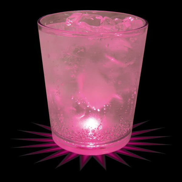 A customizable plastic rocks cup filled with pink liquid and ice with a pink LED light shining on it.