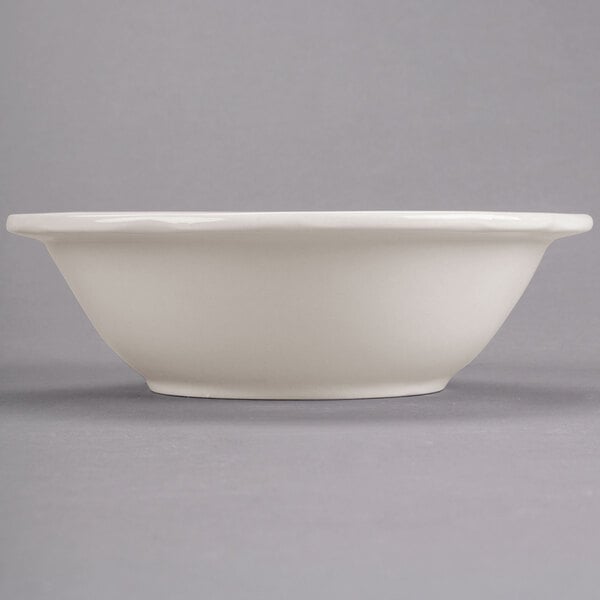 A close up of a CAC ivory scalloped edge bowl.