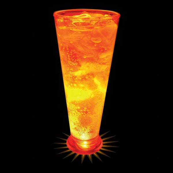 A customizable plastic pilsner cup with an orange LED light filled with orange liquid.