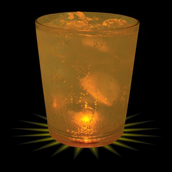 A customizable plastic rocks cup with ice and orange liquid, with a yellow LED light in it.