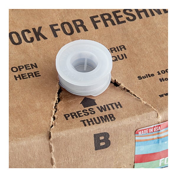 A close-up of a Original Slushie Company Cola Carbonated Slushy bag in a box with a plastic lid.