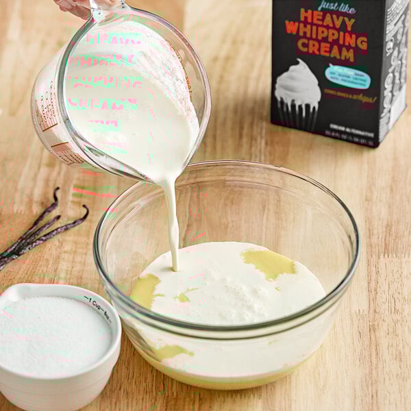 A person pouring Violife plant-based heavy cream into a bowl.