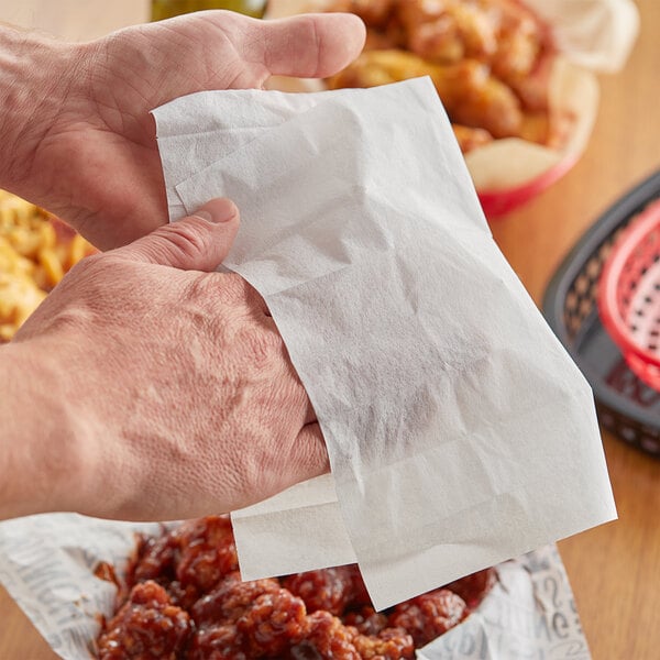 A person's hand using a Choice 70% Alcohol Antiseptic Towelette to clean their hands.