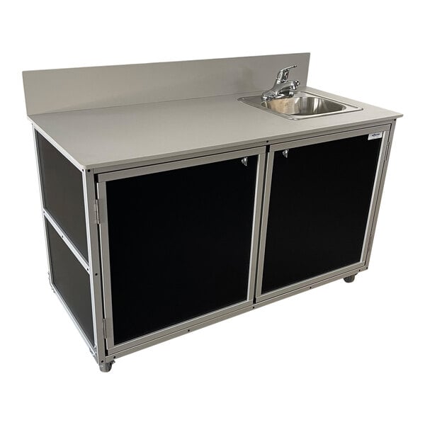 A black Monsam portable demonstration workstation with extended countertop and self-contained sink and cabinets.
