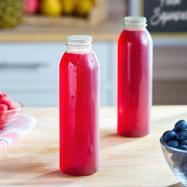 A clear 12 oz. round plastic juice bottle filled with red liquid.