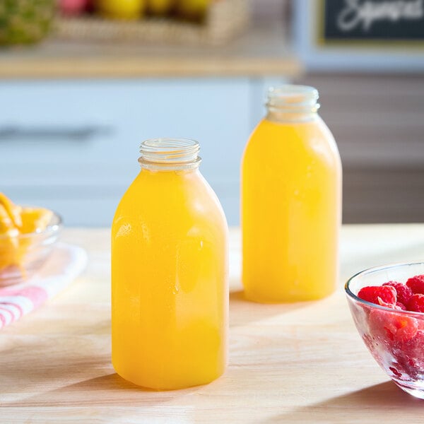A clear 12 oz. square plastic juice bottle filled with orange liquid.