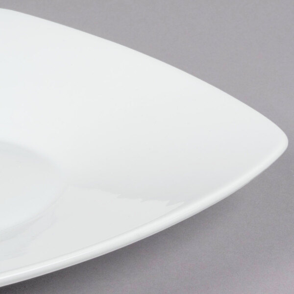 A close up of a CAC Super White porcelain square salad plate with a bowl shape.