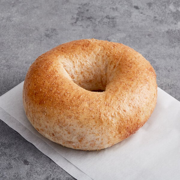 An Original Bagel New York Style Honey Wheat bagel on a white surface.