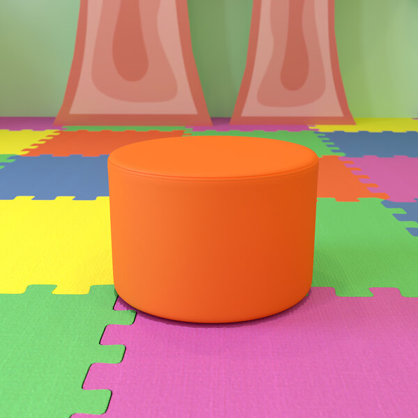 A Flash Furniture Nicholas orange round modular ottoman on a colorful surface.