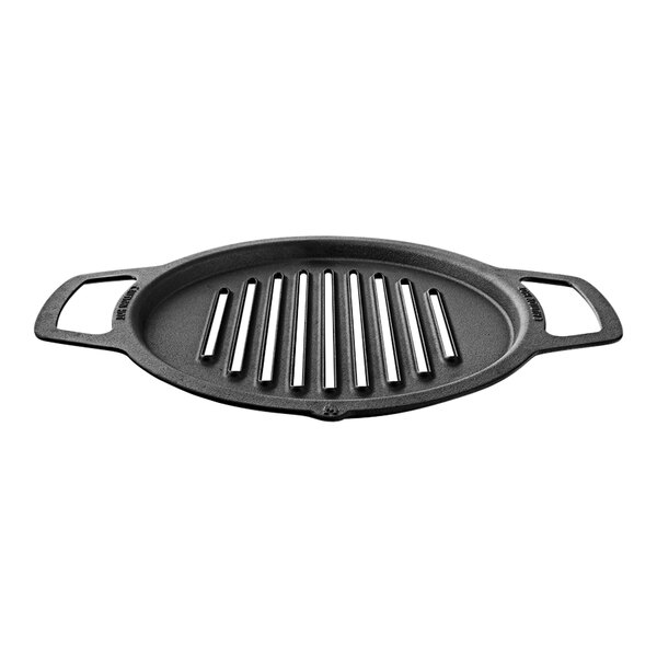 A black round grill pan with long straight lines and four small holes in it.