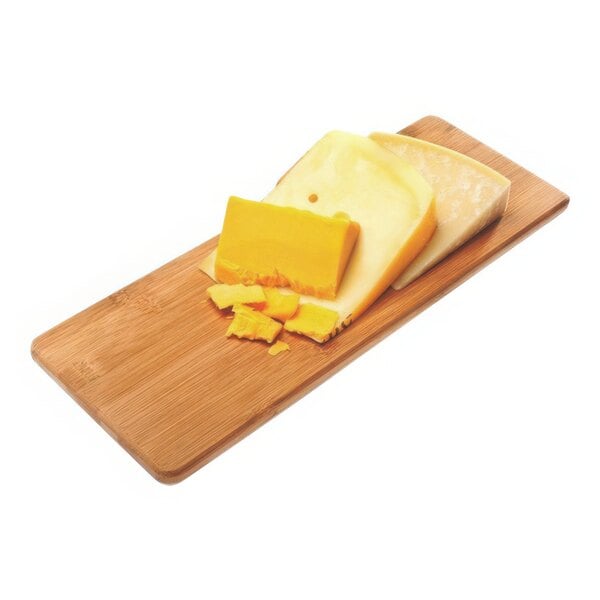 A block of cheese on a Franmara bamboo cutting board.