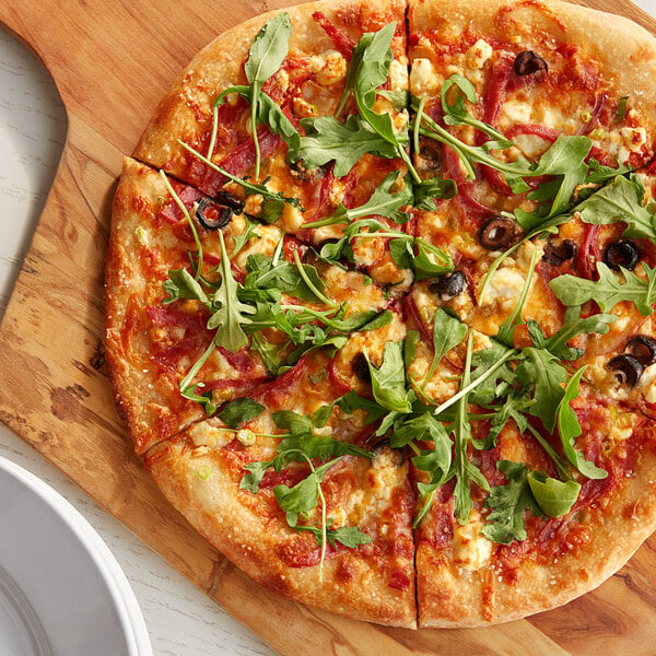 A pizza with greens on a Caputo 00 Americana Super Pizza Flour wooden board.