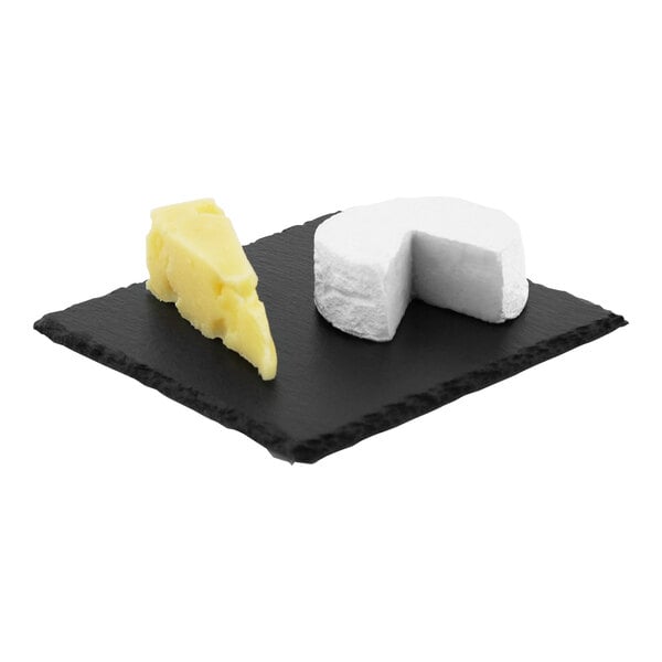 A white piece of cheese on a slate cheese tray.