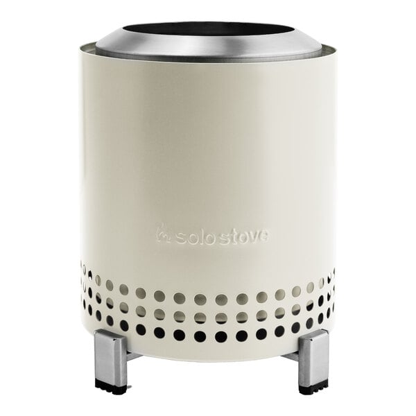 A white stainless steel cylindrical tabletop fire pit with holes in it.