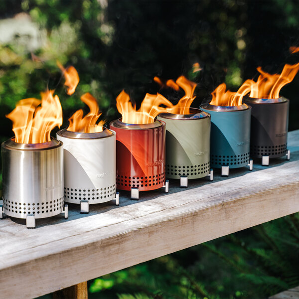 A group of white Solo Stove Mesa fire pits on a wood ledge.