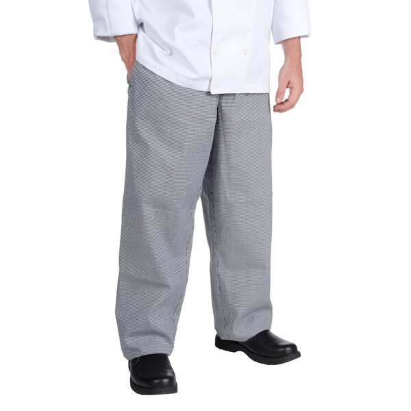 A chef wearing Chef Revival houndstooth pants and a white coat.