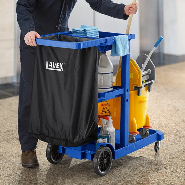 A man pushing a Lavex blue janitor cart with cleaning supplies.