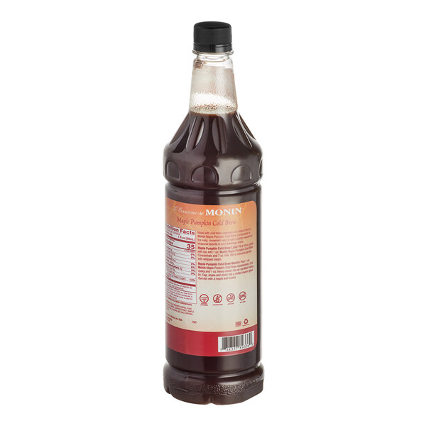 A close-up of a Monin Maple Pumpkin Cold Brew Coffee 7:1 Concentrate bottle with a label.