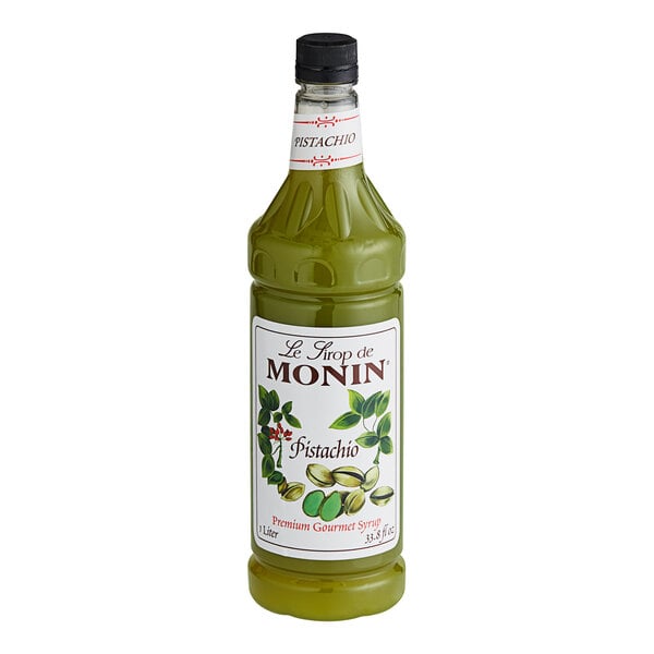A green Monin Pistachio Syrup bottle with a white label.