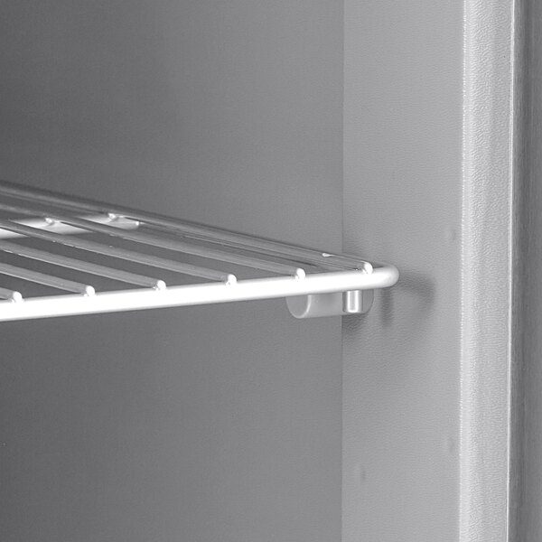 A white metal rack inside a Delfield undercounter refrigerator.