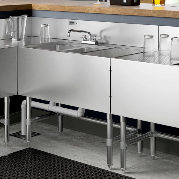 A Regency stainless steel underbar sink with a right drainboard and faucet on a counter.