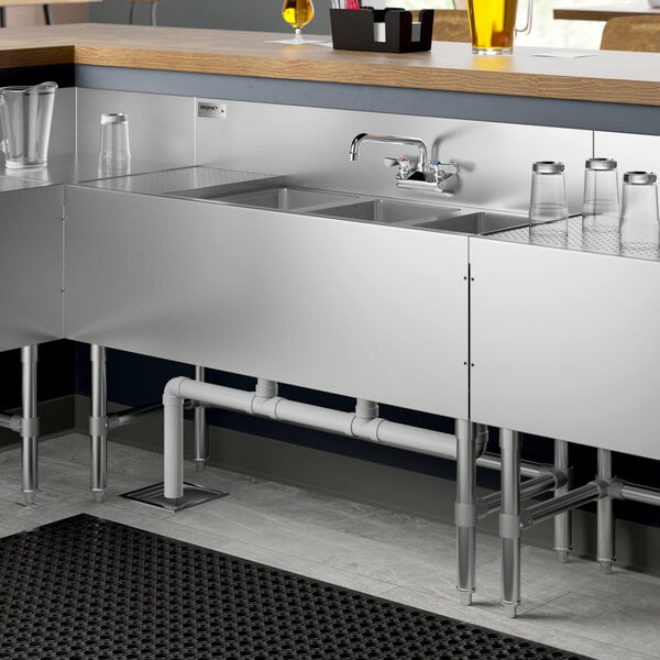 A Regency stainless steel underbar sink with a faucet and drainboard.