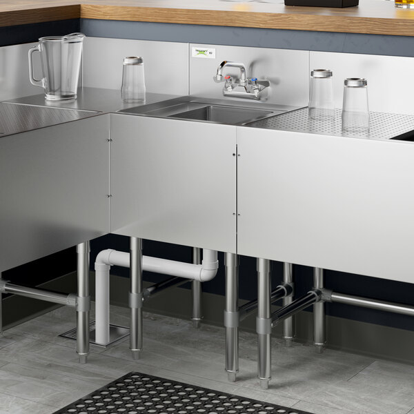 A Regency stainless steel underbar sink with faucet over a bowl with a drain.