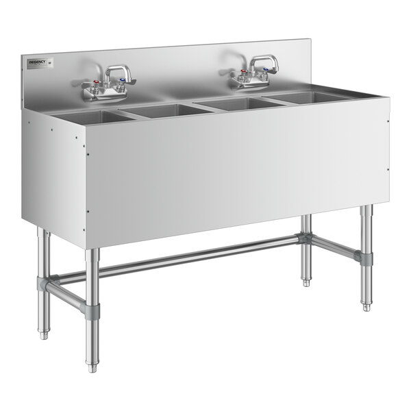 A Regency stainless steel underbar sink with four bowls and two faucets on a counter.