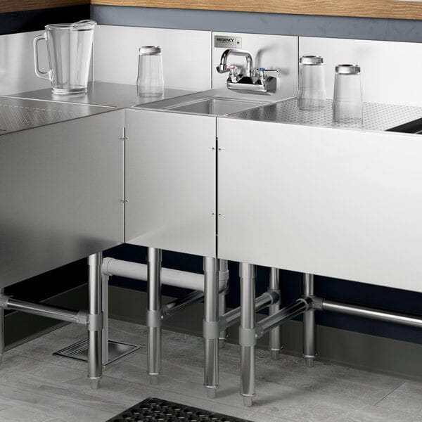 A Regency stainless steel underbar hand sink with faucet on a counter.