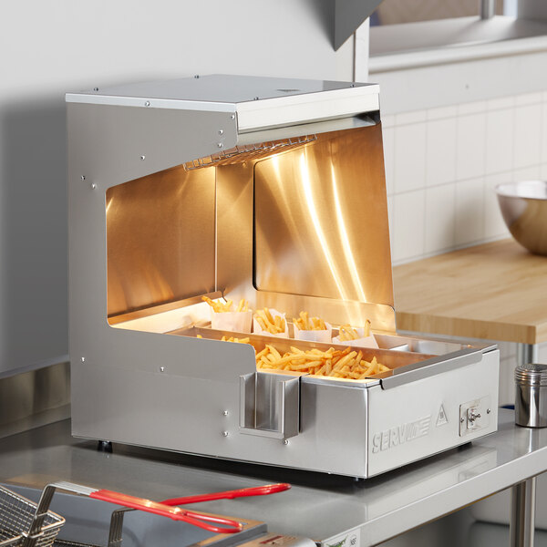 A ServIt stainless steel fry dump holding station on a counter with french fries in it.