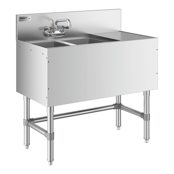 A Regency stainless steel underbar sink with two bowls, a faucet, and a right drainboard.