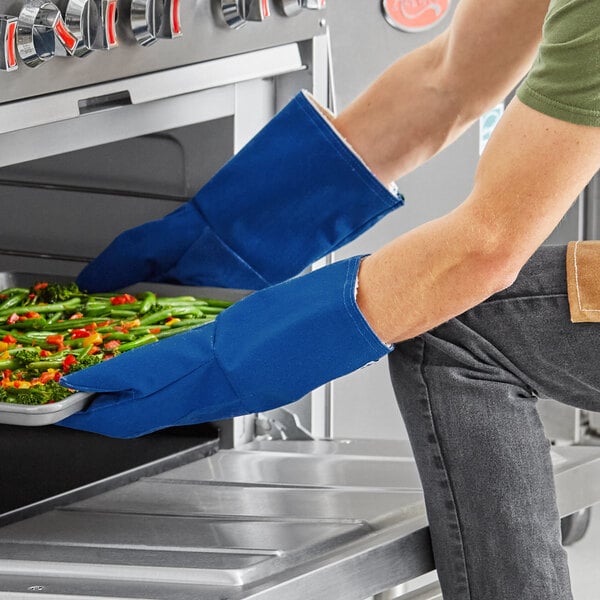 A person wearing Tucker Safety blue gloves holding a tray of food.