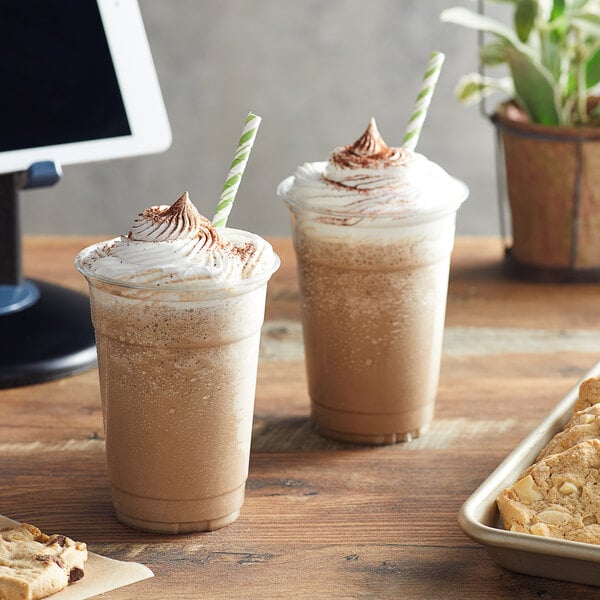 Two cups of Big Train original blended ice coffee on a table with cookies.