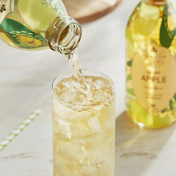 A bottle of Harney & Sons Organic Apple Juice being poured into a glass of ice.