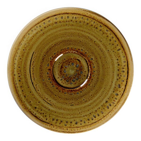 A brown saucer with a circular pattern on a brown surface.