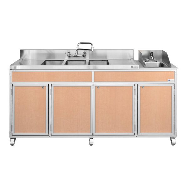A portable self-contained sink unit with four basins, two drainboards, and maple-colored cabinet doors.