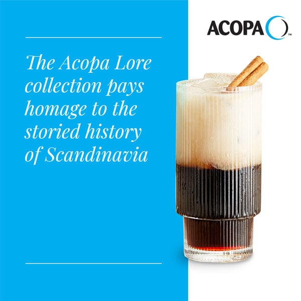 A clear, ribbed highball glass filled with a layered beverage and garnished with a cinnamon stick.