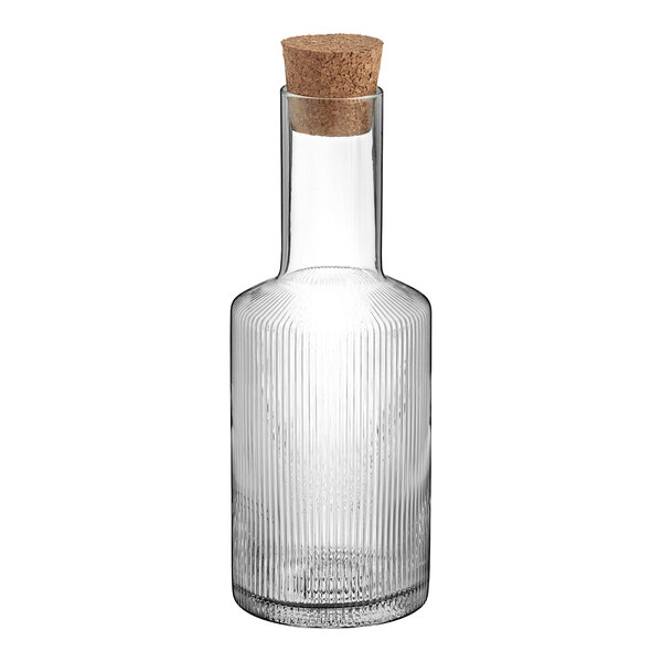 An Acopa Lore clear glass carafe with a cork stopper.