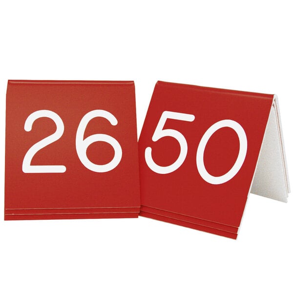 Two red Cal-Mil table tents with white engraved numbers 26 to 50.