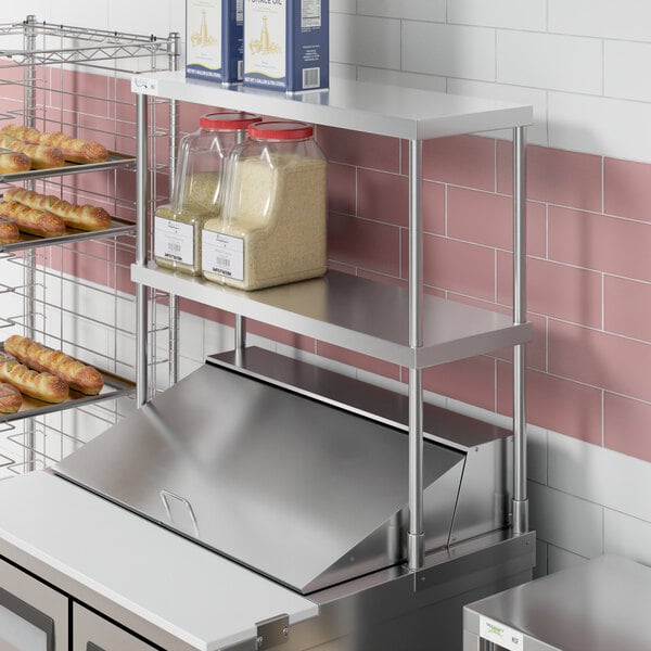 An Avantco stainless steel double deck overshelf with food on it.