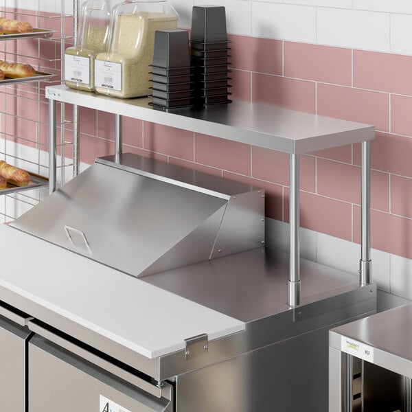 An Avantco stainless steel single deck overshelf on a counter in a kitchen.