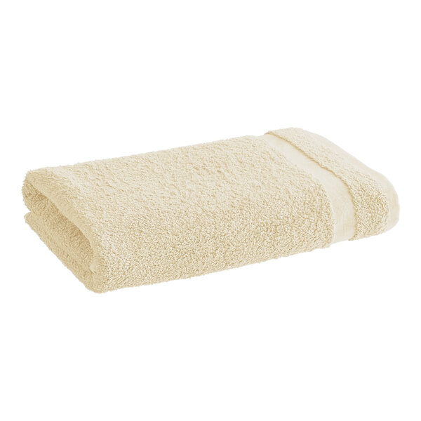 A beige 1888 Mills Fibertone bath towel.